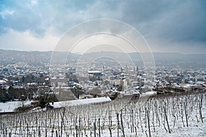 Vineyard with view of the ancient roman city of Trier covered in snow, Moselle Valley in Germany, winter landscape in rhineland