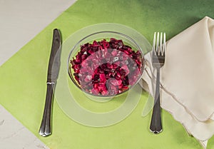 Vinigrette with a knife and fork on green background