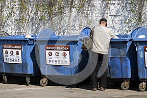 Tramp looking for food and things of garbage containers