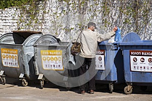 Tramp looking for food and things of garbage containers