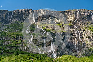 Vinnufallet in summer sunlight, flushing down a green mountainside in Norway