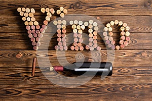 Vino lettering with bottle of wine on wood photo