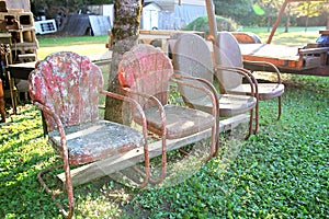 Vinrtage Red Metal Chairs Lined Up at Antique Salvage Yard photo