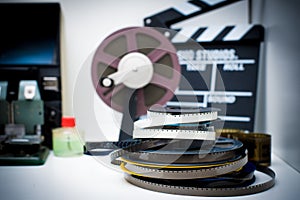 A vintage 8mm movie editing desktop with reels and clapper