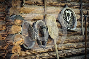 vintage accessories, old horse harness and household items on the background of a rough wooden log wall