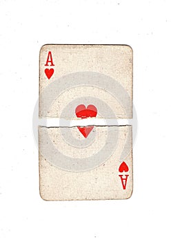 A vintage ace of hearts playing card torn in half.