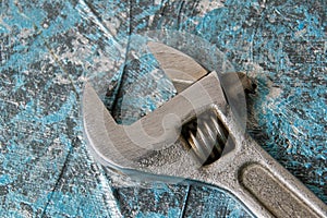 Vintage adjustable spanner on a blue background