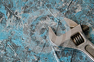 Vintage adjustable spanner on a blue background