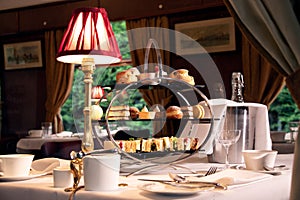 Vintage afternoon tea stand through window of train compartment