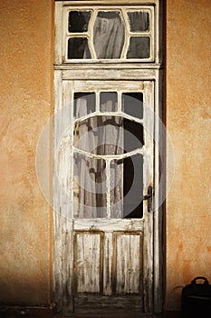 Vintage, aged door with a window panel.