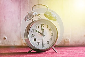 Vintage alarm clock on a red white background, toning