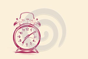 Vintage alarm clock on a sand colored background with space for copy in a duo tone red and creme colored design image photo