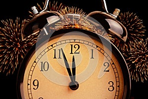 Vintage alarm clock is showing midnight. It is twelve o`clock, holiday happy new year festive concept on light glittering sparkle