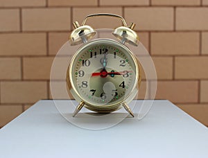 Vintage Alarm Clock On A Wooden Cube On A Bricks Background