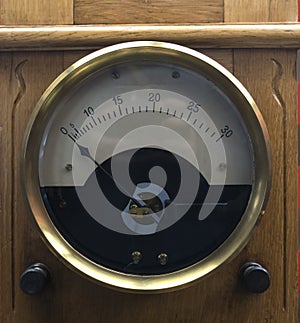 Vintage analogue ammeter made of metal on a wooden work bench