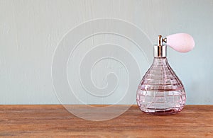 Vintage antigue perfume bottle, on wooden table
