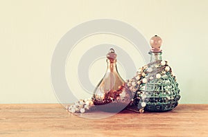 Vintage antigue perfume bottles, on wooden table. retro filtered image