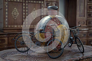 Vintage antique asian vase with bicycle figures on a wooden table
