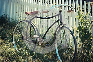Antique bicycle leaning on a fence