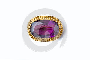 Vintage antique brooch with a large semi-precious purple stone on white background. Oldfashioned decoration from grandma`s jewelr photo