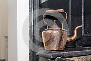 Vintage and antique copper kettle on a Victorian stove in a trad