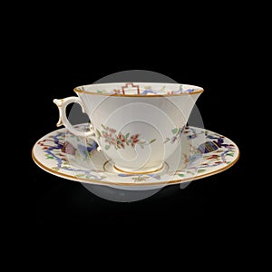 Vintage antique cup on saucer hand painted on black isolated background.