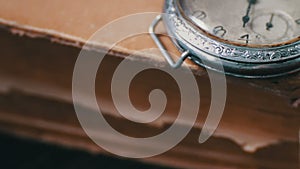 Vintage antique pocket watch on the background of old books.