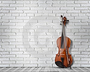 Vintage antique violin near brick wall background.