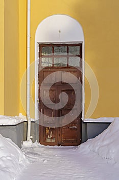 Vintage antique wooden door on entrance to old town house in winter