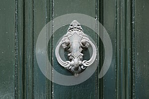 Vintage antiqued door knocker on wooden green door photo