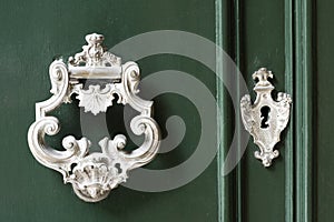 Vintage antiqued door knocker on wooden green door