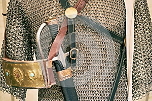 Vintage armor, retro chain mail and a sword in a scabbard. Ancient military arsenal of the events of the Russian-Swedish war