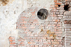 Vintage background texture of old brick masonry on ancient cement with cracks with traces of old paint.