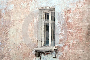 Vintage background with the texture of an old plastered damaged wall with a window. Grunge background of urban decay