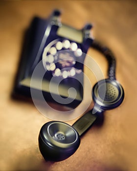 Vintage bakelite dial telephone on rustic metal surface. Selective focus