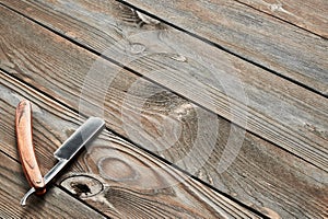 Vintage barber shop straight razor tool on wooden background