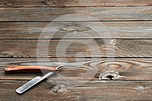 Vintage barber shop straight razor tool on wooden background