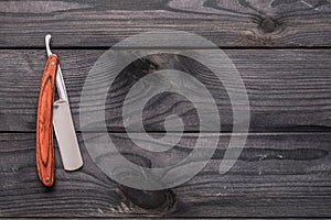 Vintage barber shop straight razor tool on wooden background