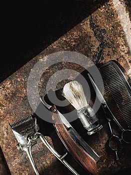 vintage barber tools: dangerous razor, hairdressing scissors, old manual clipper, comb, shaving brush