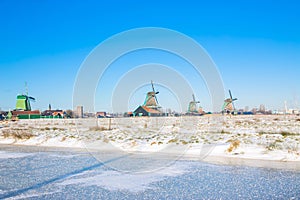 Vintage beautiful Dutch houses, old windmills, frozen water in canals and rivers
