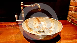 Vintage Beautiful faucet and golden mixer tap on a marble round sink in the bathroom. Interior of an expensive toilet with a