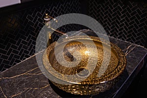 Vintage Beautiful faucet and golden mixer tap on a marble round sink in the bathroom. Interior of an expensive toilet