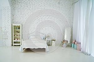 Vintage bed with pillows and a vase of flowers stand on the bedside table 1