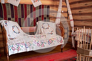 Vintage bed in a Russian hut. Decoration of an old house.