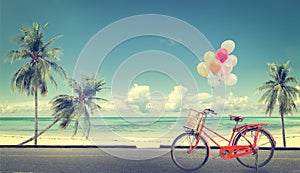 Vintage bicycle with balloon on beach blue sky