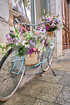 vintage bicycle decorated with wicker baskets hanging from the handlebars full of beautiful flowers, girona flower festival ,