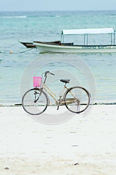 Vintage bicycle parked on beach. Retro bike near the sea . blurred boat in the foreground