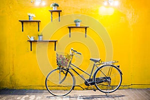 Vintage bicycle on vintage yellow wall