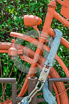 Vintage bike locked and completly painted in orange