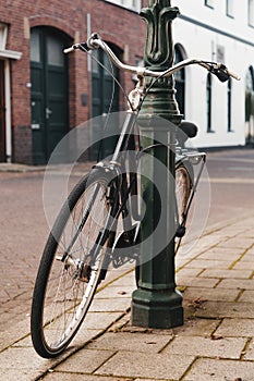 Vintage bike parked and locked on a street light post